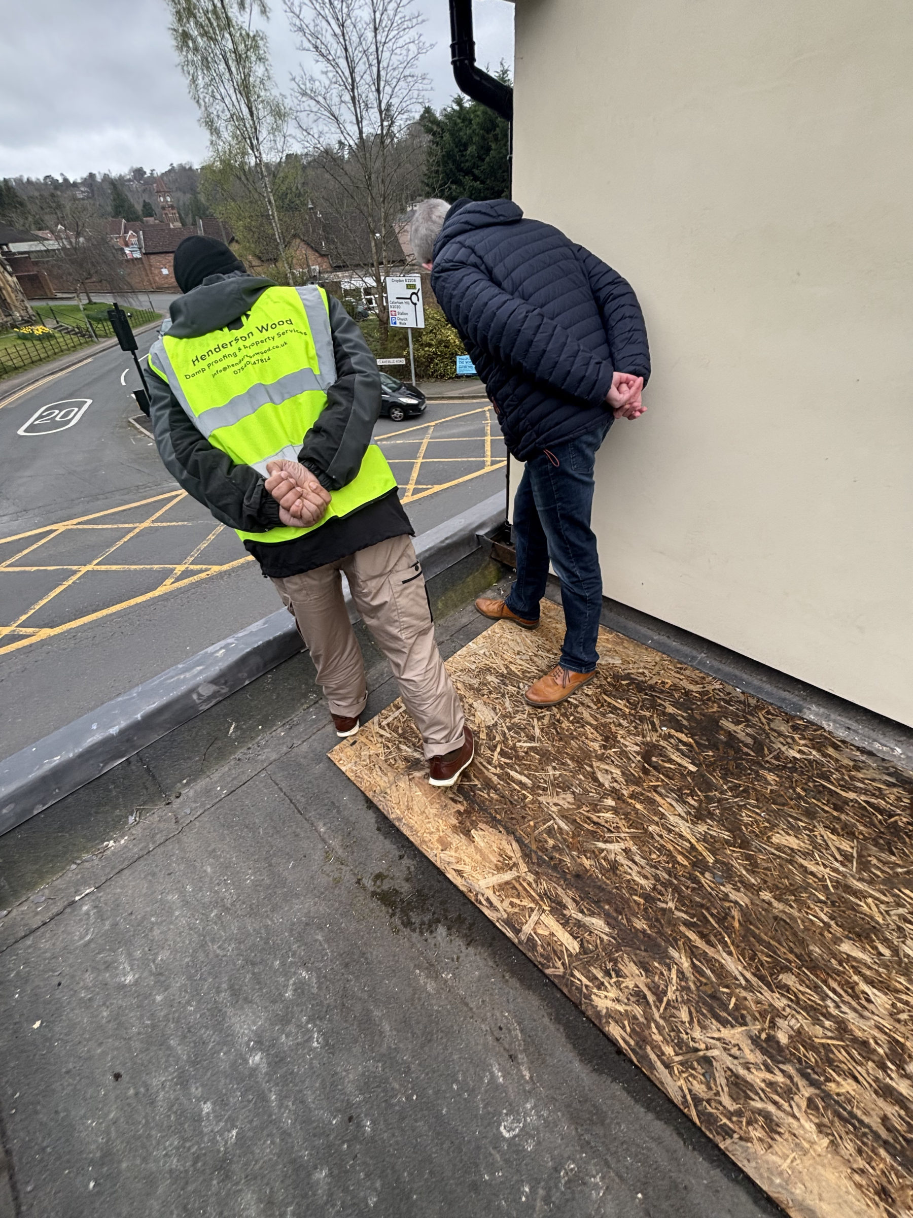 Henderson Wood surveyor walking a seller through an exterior damp check before sale